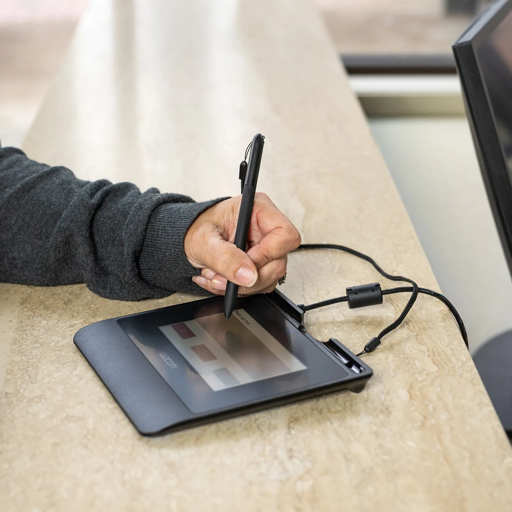Una persona firma su un pad di firma con la penna
